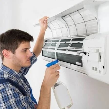 Technician cleaning air conditioning coil and filter assembly