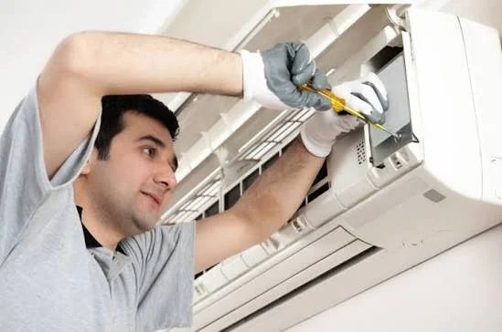 Technician servicing indoor wall-mounted split air conditioning unit